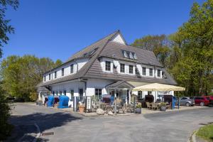 a large white building with a gambrel roof at Dünenhotel am Meer in Warnemünde