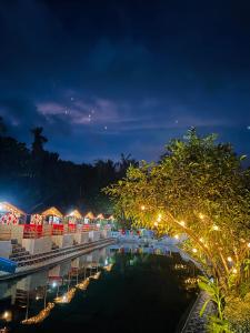 a resort with a pool and lights at night at Tuburan Resort in Panong