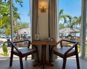 a table and two chairs in a room with a window at Binucot Pearl Boutique Resort in Ferrol