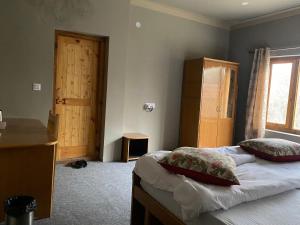 a bedroom with two beds and a window and a door at Tsogstot residency in Deskit