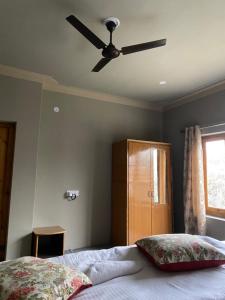 a bedroom with a ceiling fan and a bed at Tsogstot residency in Deskit