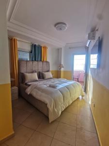 a bedroom with a large bed and a large window at Studio VIP - 01 chambre - Bonamoussadi groupe électrogène - 2douches in Douala