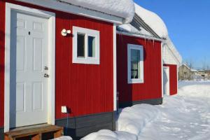 a red house with a white door in the snow at The Downtown Loft in Fairbanks