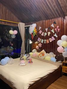a room with a bed with balloons and a happy birthday sign at A Phủ Home's Tà Xùa in Bắc Yên