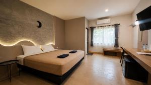 a hotel room with a bed and a desk at JanJao Resort in Nakhon Sawan