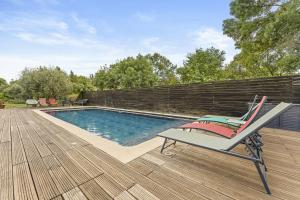 a chair sitting on a deck next to a swimming pool at Mas Abicou in Vézénobres