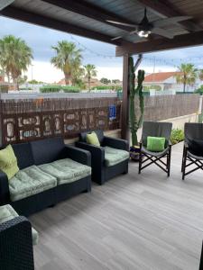 eine Terrasse mit zwei Sofas und zwei Stühlen in der Unterkunft Riumar Nature 38 , piscina , aire acondicionado , barbacoa y pàrquing Privado in Riumar