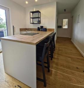 a kitchen with a counter with a bar with chairs at Fischstübchen Neeberg Fewo 4 – Schwalbennest in Krummin +47 photos