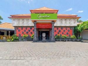 a building with a sign that reads gujarat stores at Guntur Hotel Bali in Ketewel