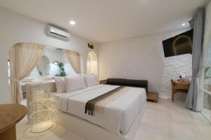 a bedroom with a large white bed in a room at Makyra by Bohemian Jogja Villas in Kejayan