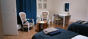 a bedroom with a bed and chairs and a desk at Le Voltaire in Airvault