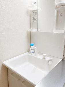 a bathroom with a white sink and a mirror at KANAU in Tokyo
