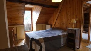 a bedroom with a bed in a log cabin at Maison La Picade in Saint-Mamet
