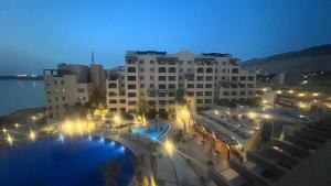 a large building with a pool in front of it at night at Bella by the Sea in Sowayma
