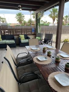 ein Holztisch und Stühle auf einer Terrasse in der Unterkunft Riumar Nature 38 , piscina , aire acondicionado , barbacoa y pàrquing Privado in Riumar