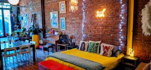 a bedroom with a bed and a brick wall at Cat-themed East City Loft Apartment in Cape Town