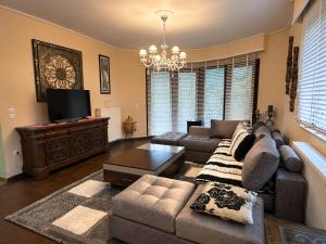 a living room with a couch and a television at Peaceful Retreat - Kefalos Stay with Patio views & gym in Kefalos