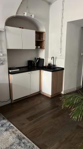 a kitchen with white cabinets and a wooden floor at Rynek 5 Winiarnia in Lublin