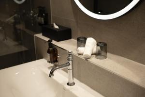 a bathroom sink with a faucet and a mirror at Hotel Des Alpes in Lucerne +83 photos