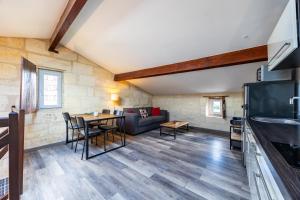 a living room with a couch and a table at Le Loft - Château Le Noble in Saint-Germain-du-Puch