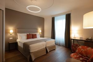 a hotel room with a bed and a chair at Hotel Des Alpes in Lucerne