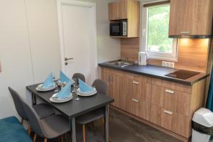 a kitchen with a table with chairs and a sink at Igal Thermal Camping in Igal +10 photos