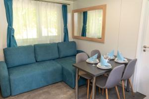 a living room with a blue couch and a table at Igal Thermal Camping in Igal