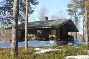 a log cabin in the woods with snow and trees at River Cabin Urpo in Inari