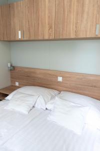 a bed with two white pillows and a wooden headboard at Igal Thermal Camping in Igal