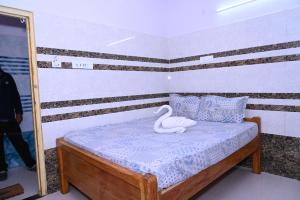 a bedroom with a swan toy on a bed at Gitanjali Lodge in Rāmagiri Udayagiri +28 photos
