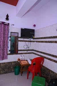 a room with a table and two red chairs at Gitanjali Lodge in Rāmagiri Udayagiri
