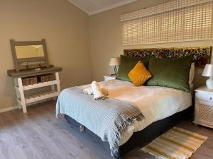 a bedroom with a bed with green and yellow pillows at Eight Umdoni North in Pennington +29 photos