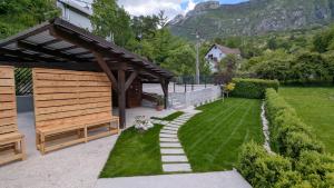 a garden with a wooden pavilion and green grass at Apartmaji Pippi in Bovec