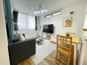 a living room with a couch and a table at エムズ千歳幸町2 in Chitose