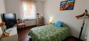 a bedroom with a bed and a flat screen tv at Casa junto al mar in Vinarós