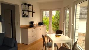 a kitchen with a table and a small kitchen with a table and chairs at Fischstübchen Neeberg Fewo 5 – Bootshaus in Krummin