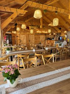 a restaurant with wooden tables and chairs and lights at Leśne Ustronie in Lubiszewo
