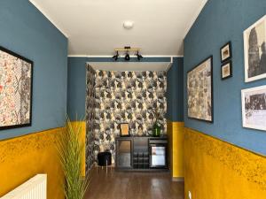 a living room with blue and yellow walls and a fireplace at Pension ElbeStay in Königstein an der Elbe
