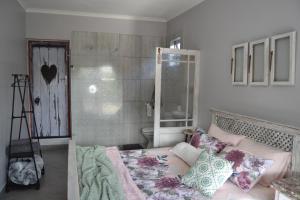 a bedroom with a bed with pillows and a shower at Cozy Rustic Cottage in Windsor Park