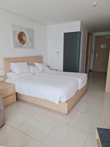 a bedroom with a large bed with white sheets at Beachfront A405 Seaview Studio Rawai Phuket in Ban Saiyuan (1) +19 photos