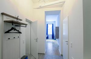 a hallway with white walls and a white door and a room at Indigo am Gürtel in Vienna