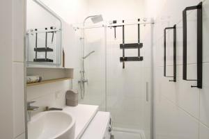 a white bathroom with a sink and a toilet at Indigo am Gürtel in Vienna +5 photos