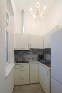 a kitchen with white cabinets and a chandelier at Indigo am Gürtel in Vienna