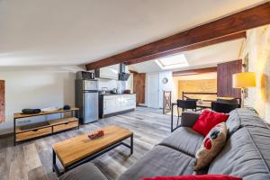 a living room with a couch and a table at Le Loft - Château Le Noble in Saint-Germain-du-Puch