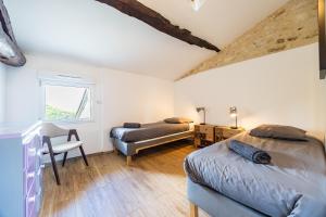a bedroom with two beds and a chair and a window at La Ferme - Château Le Noble in Saint-Germain-du-Puch