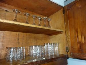una fila de vasos en una pared de madera en Como en Casa en Eugenio Bustos