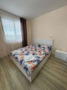 a bedroom with a bed with a floral bedspread at Равда Аполон 9 in Nesebar