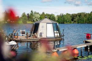 a small boat parked at a dock on a lake at Koivuranta Igloos in Oulu