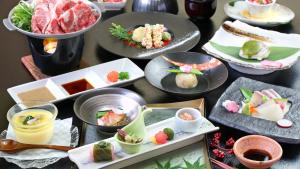 a table with many plates of food on it at Gogaku Hotel in Aso