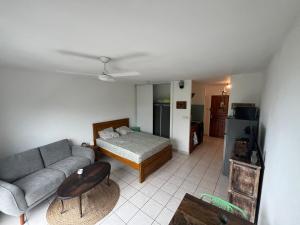a living room with a couch and a bed at Petite Case cade in Sainte-Marie